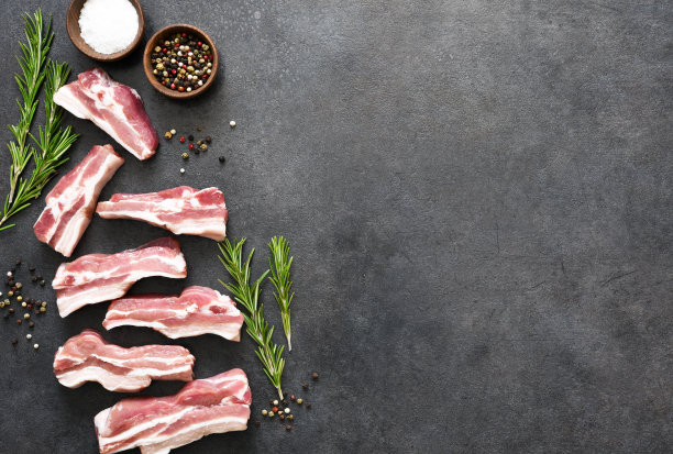 生肋排与迷迭香在黑色的石头背景。从以上观点。图片下载