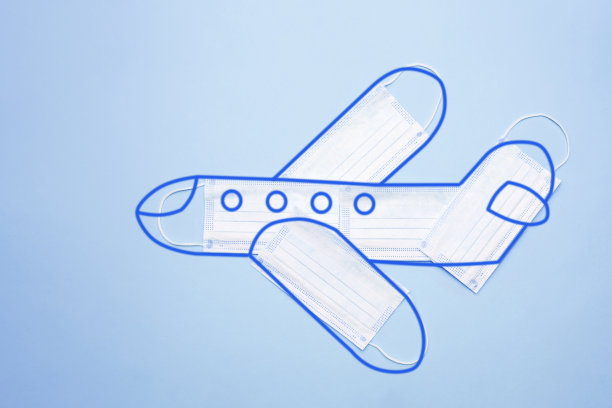 飞机模型由防护口罩制成，蓝色背景上有一个轮廓。乘飞机安全旅行的概念图片下载