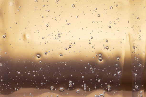 纹理背景与泡沫和滴在黄金背景。透明质酸凝胶。化妆品的背景。图片下载