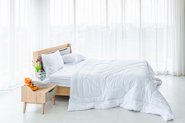 室内白色的卧室，白色的窗帘和白色的枕头在木床上图片下载
