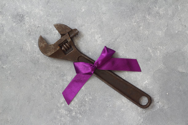 以旧工具为背景的工艺礼品。父亲节的概念。平的。扳手的礼物。图片下载