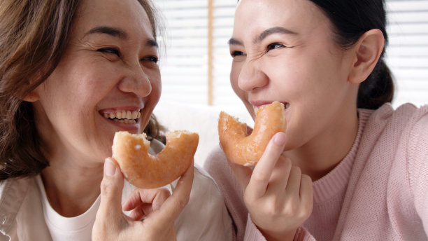 偷拍的迷人的美丽的两人家庭用手机拍照照片甜甜圈视频故事笑脸大喜甜甜圈在沙发沙发客厅一起度过美好的时光隔离社会距离。图片下载