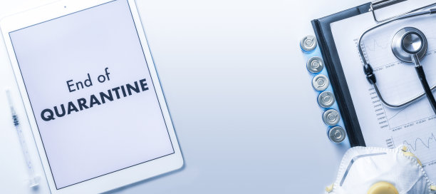 检疫结束了。带针的注射器、医院保健图表、医生听诊器和屏幕上显示医疗设备背景文字的白色平板。隔离概念结束。图片下载