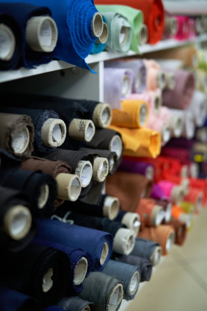 色彩斑斓的布料卷在工作室里。女装裁缝概念图片下载