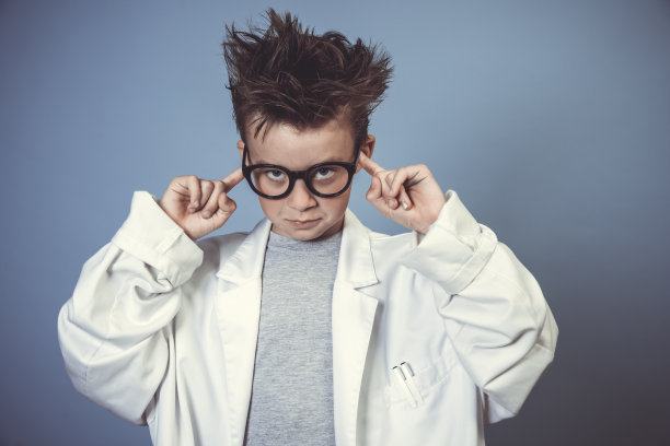 戴着厚厚的黑眼镜的酷学生打扮成穿着白大褂的疯狂科学家图片下载