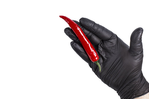 豆荚的红辣椒在右手戴着黑色手套，俯视图，孤立在白色图片下载