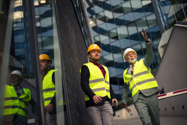 成熟的工程师讨论建筑结构与建筑师的同事在施工坐图片下载