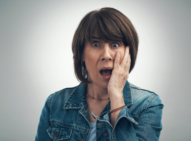 画室里的一位年长妇女的肖像，在灰色的背景下看起来很震惊图片下载