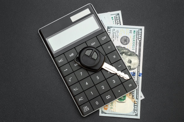 汽车钥匙计算器和金钱在黑色背景。图片下载