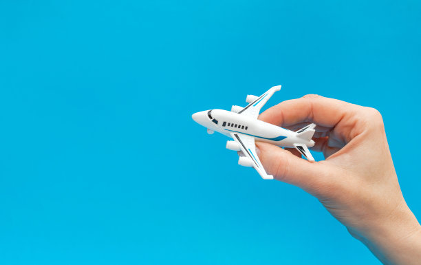 在蓝色背景下拿着飞机玩具的女人。关闭了。图片下载