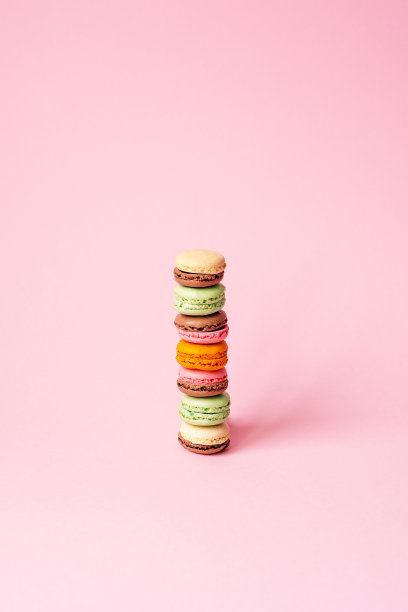 一堆多色的杏仁饼干在粉红色的背景上，复制空间图片下载