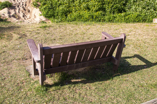 沙滩边的绿草上的长椅图片下载