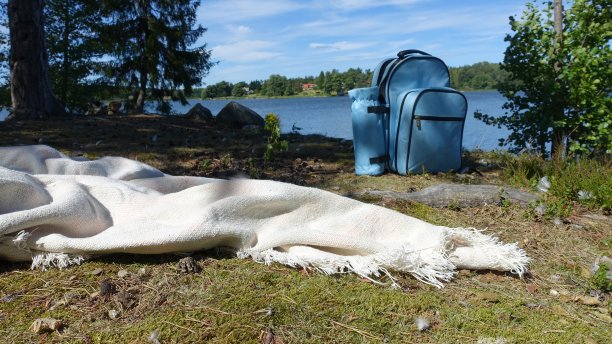 蓝色的背包和一条毯子留在了湖岸。图片下载
