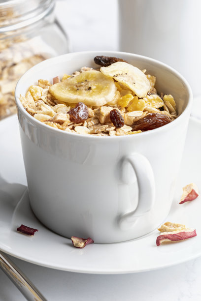 早餐一碗牛奶和全谷物。什锦麦片和干果。在光的背景。图片下载