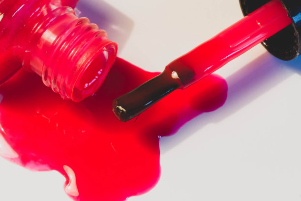 鲜红的指甲油洒在白色的桌子上图片下载