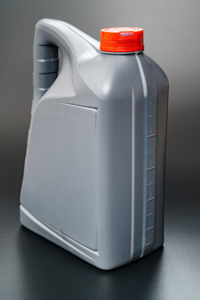 灰色与红色盖罐与机油在黑色背景。图片下载