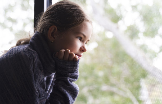 一个白人女孩看着窗外图片下载