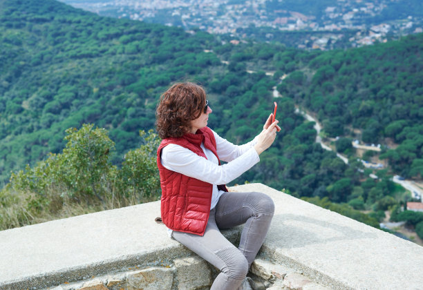 一名中年妇女在旅游景点自拍图片下载