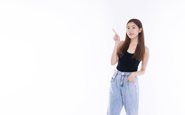 漂亮女孩微笑点展示广告。开朗的年轻女子用手指指着产品或空白的拷贝空间，而站在孤立的白色背景上。图片下载