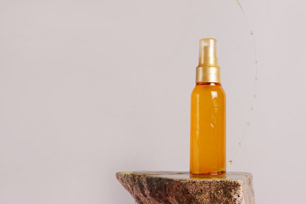 在灰色背景的石头上滴着头发的化妆油瓶，copyspace图片下载