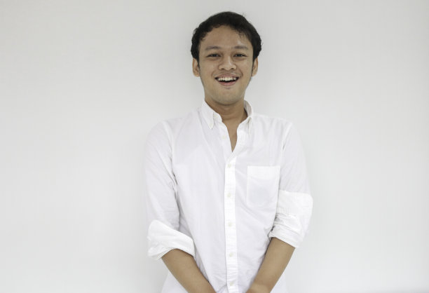 年轻有趣的亚洲人的肖像与白衬衫看相机和微笑快乐的表情图片下载