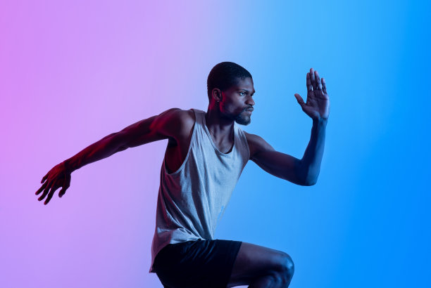 下定决心的年轻黑人运动员在霓虹灯下赛跑图片下载
