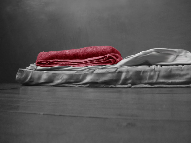 悲伤而孤独的气氛，牢房地板上的床垫上放着廉价毛毯图片下载