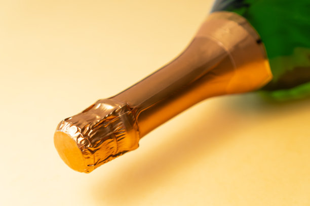 瓶气泡酒近距离，在粉红色的背景。有选择性的重点。图片下载