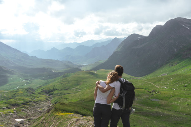 相爱的年轻夫妇看瑞士阿尔卑斯山壮丽的全景图片下载