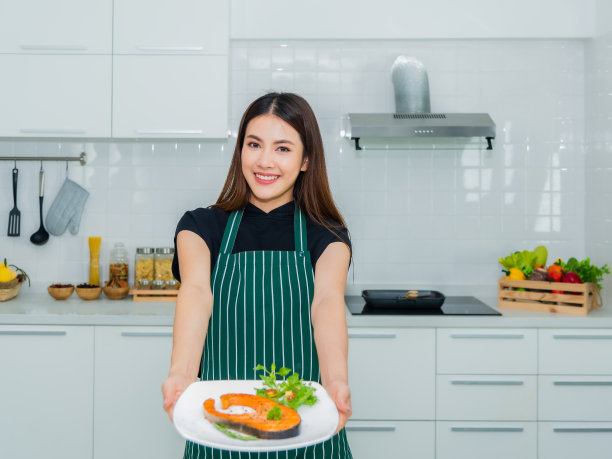 美丽的亚洲女人站在微笑拿着盘子鲑鱼排图片下载