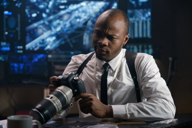 侦探在一个现代化的高科技警察局，他研究在一个秘密的特别行动中拍摄的照片。图片下载