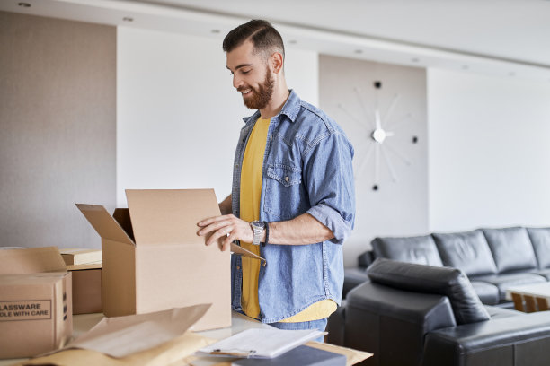 在网上商店工作的人。男人，小公司的老板把产品包装在盒子里，准备发货。图片下载