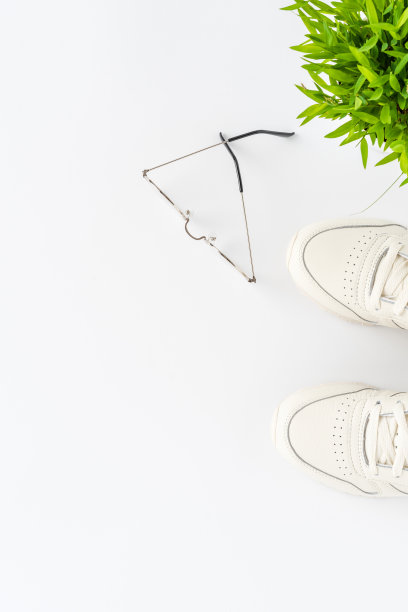 头顶拍摄的服装与运动鞋和眼镜在白色背景与copyspace。女人的生活方式。俯视图图片下载