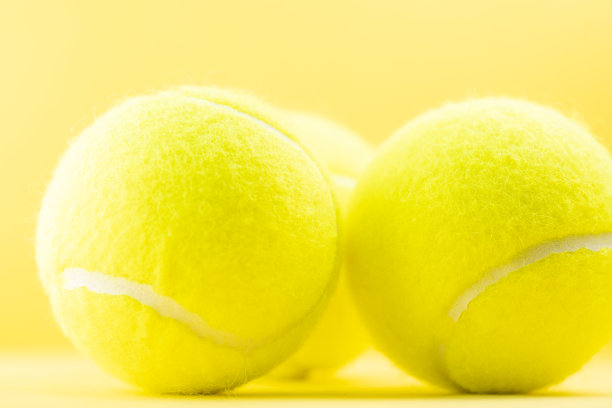 黄色背景上的网球图片下载