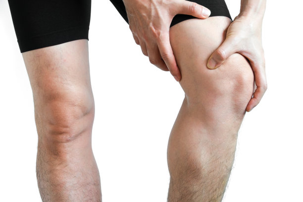运动男子与膝盖疼痛和握住她的膝盖，在白色的背景，健康护理和运动的概念。图片下载