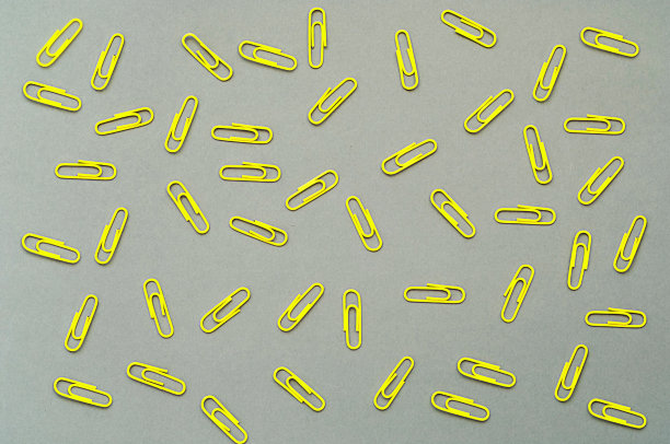 灰色背景上的黄色回形针。
2021年的流行色。特写镜头图片下载