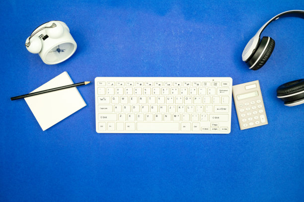 俯视图的业务对象键盘，鼠标，耳机，文书与铅笔和闹钟在蓝色的纸背景最小的平坦的放置复制空间的业务背景和网站图片下载