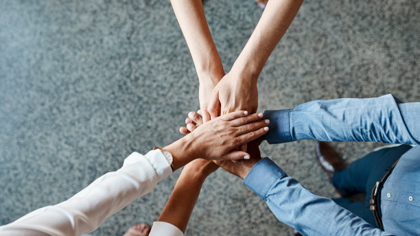 高角镜头拍摄的是一群完全认不出来的商人聚在一起，手挽着手图片下载