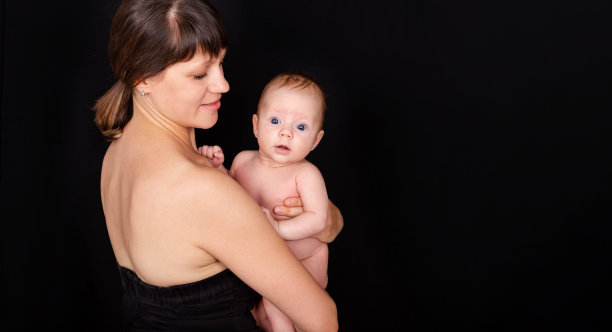 快乐的妈妈亲吻着宝贝男孩。照顾婴儿皮肤的母亲。图片下载