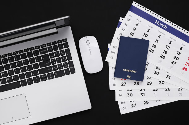 时间旅行。带日历的笔记本电脑，黑色背景的护照。前视图。图片下载