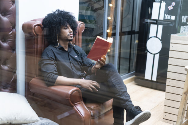 一个黑发的拉丁男子正在他的工作场所全神贯注地阅读图片下载