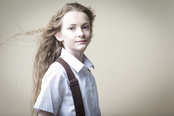 青少年生活方式的概念。美丽的白人金发少女的肖像在休闲服装与背带对米色摆姿势。水平方向图片下载