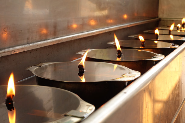 手往灯里倒油许愿，往灯里加油，做佛功，为泰国寺庙做佛功(维萨佛节，阿萨佛节，摩诃佛节)图片下载