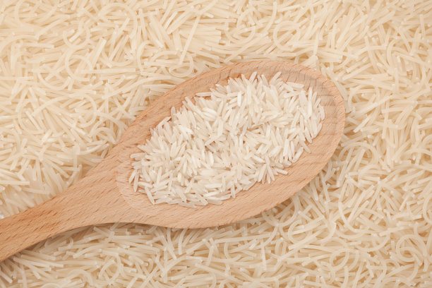 木勺里的米饭，特写。白色粉条或日本生米粉的背景。无谷蛋白产品图片下载