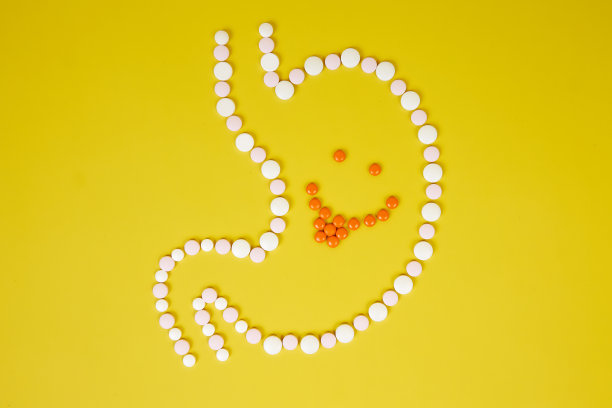 吃了药的胃里露出了一张快乐的脸，黄色的背景上露出了它的舌头。图片下载