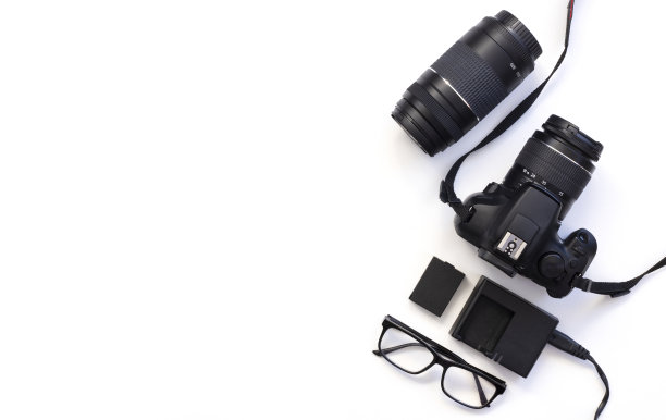 用数码相机，镜头，眼镜，相机配件在白色的桌子背景俯视图的摄影师图片下载