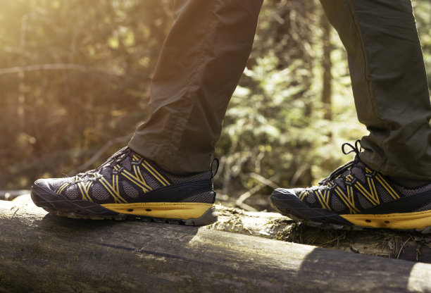 男性的腿在运动鞋特写，行走在夏天的森林。徒步旅行的概念图片下载