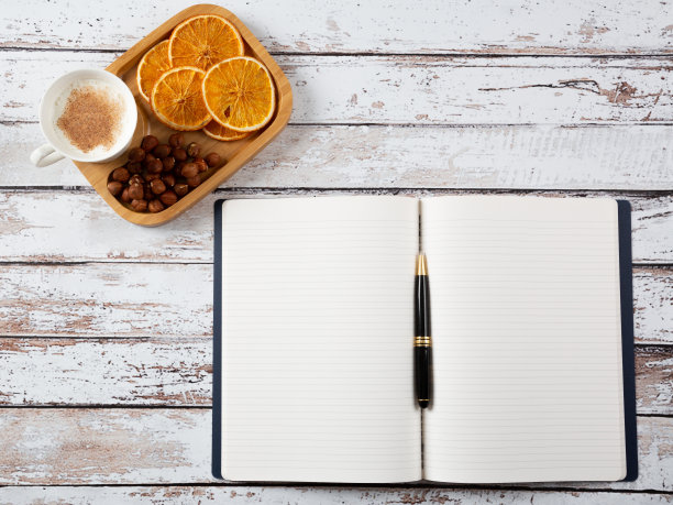 直接上方拍摄的打开笔记本与钢笔和一杯热牛奶与肉桂在白色质朴的桌子。图片下载