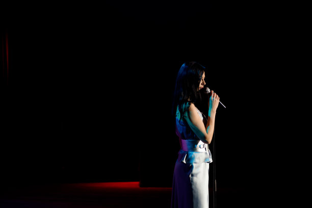 歌手与麦克风在色彩斑斓的灯光舞台背景图片下载