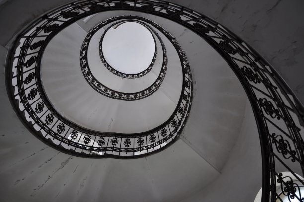 在旧建筑内设计螺旋楼梯，圆形的建筑形状。克罗地亚里耶卡的老房子里的老螺旋楼梯的黑白照片。螺旋楼梯。图片下载